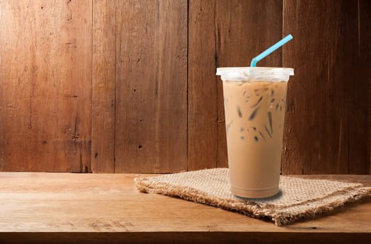 Ice milk coffee and coffee bean on empty wooden copy space in still life style