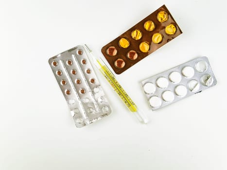Mercury medical thermometer and pills on a white background. Place for text. Medicine and health.