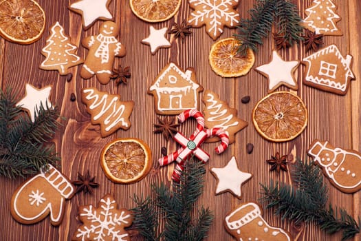 Christmas gingerbreads. Christmas decorations. Handmade cookies, fir branches with decorations on the wooden table. Top view. Christmas and New Year treats.