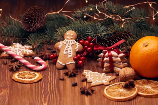 Christmas gingerbreads. Christmas decorations. Handmade cookies, fir branches with decorations on the wooden table. Christmas and New Year treats.