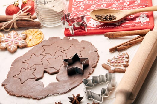 Decorating gingerbreads. Dough, rolling pin, shape cutter for handmade cookies, confection lying on the wooden background. Christmas and New Year treats.