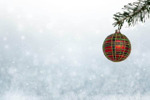 Christmas or New year card template. Christmas ball on a snowy branch over abstract light blue christmas background with stars. Copy space for text design.