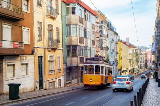 Traditional yellow tram in Lisbon downtown street, sunny weather, Portugal