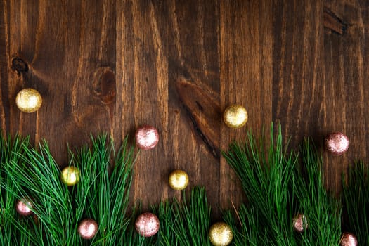 Pine boughs with christmas decorations on wooden surface with copy space.