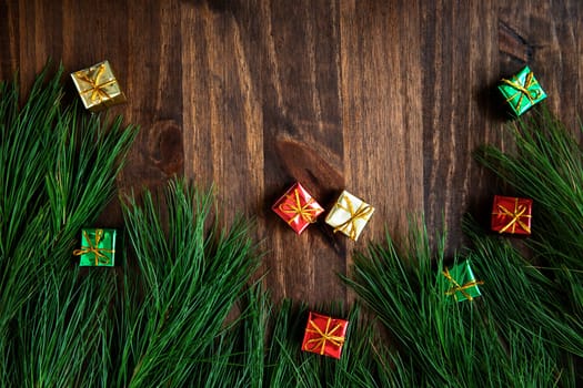 Pine boughs with christmas decorations on wooden surface with copy space.