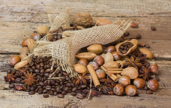 coffee beans, nuts and spices on old wooden background