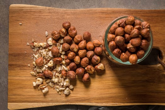 Kitchen cutting board with hazelnuts without shell, view from above.