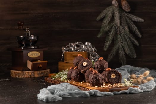 Dark chocolate truffles with hazelnuts over wooden cutting board.
