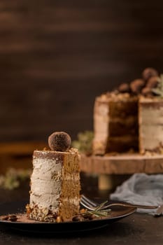 Slice of delicious naked coffee and hazelnuts cake on table rustic wood kitchen countertop.