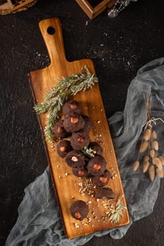 Dark chocolate truffles with hazelnuts over wooden cutting board.