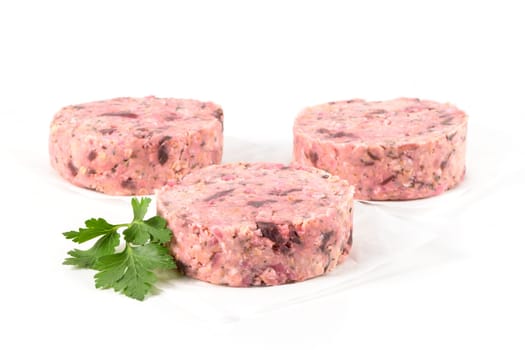 Raw veggie burger with beetroot and white beans with parsley leaves on white background.