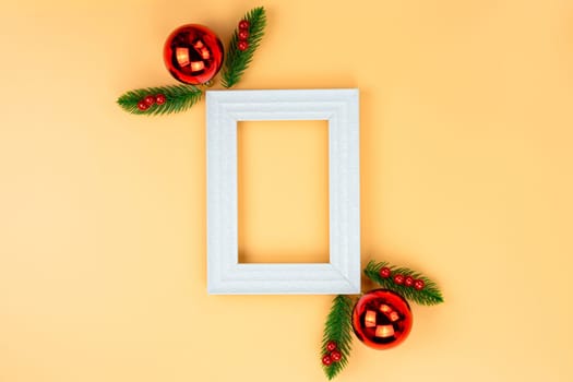Christmas holidays composition, top view of red Christmas decorations and picture frame on yellow background with copy space for text. Flat lay, winter, postcard template, new year concept.