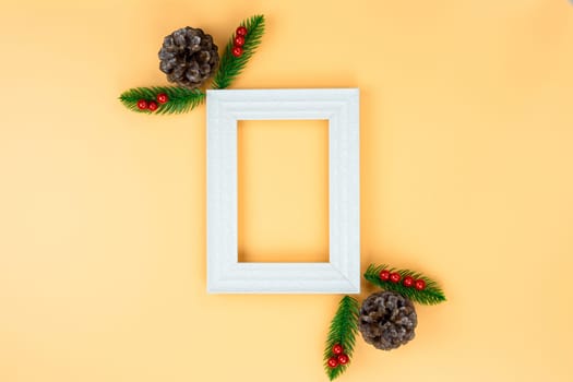Christmas holidays composition, top view of red Christmas decorations and picture frame on yellow background with copy space for text. Flat lay, winter, postcard template, new year concept.