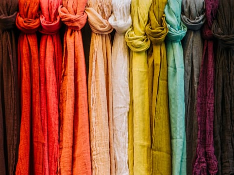 Row of colorful scarves hanging in a outside market.