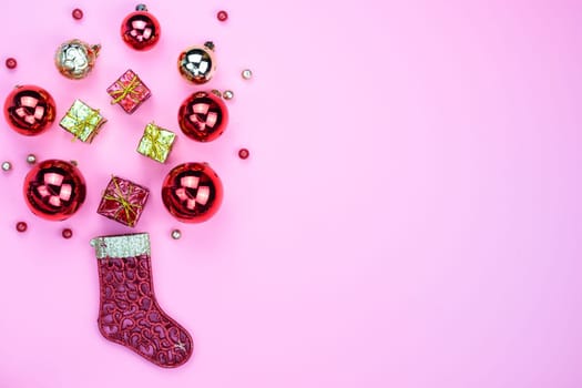 Christmas holidays composition, top view of red Christmas decorations on pink background with copy space for text. Flat lay, winter, postcard template, new year concept.