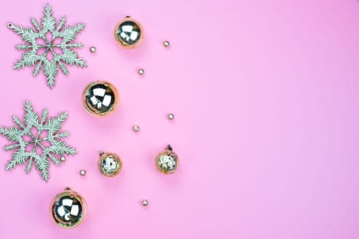 Christmas holidays composition, top view of gold Christmas decorations on pink background with copy space for text. Flat lay, winter, postcard template, new year concept.