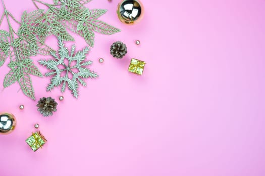 Christmas holidays composition, top view of gold Christmas decorations on pink background with copy space for text. Flat lay, winter, postcard template, new year concept.