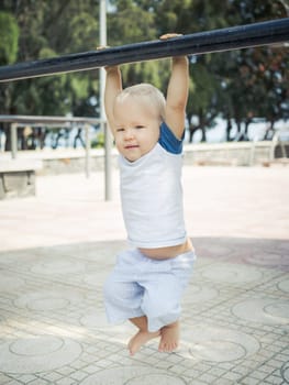 Baby hanging on a pull-up bar