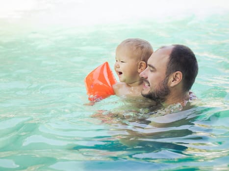 Baby and father in swimming pool