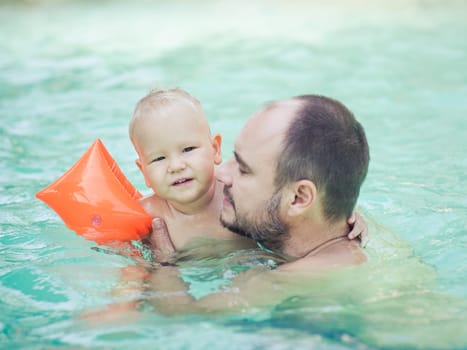 Baby and father in swimming pool