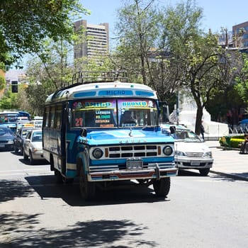 LA PAZ, BOLIVIA - OCTOBER 15, 2014: An old blue Dodge D400 bus used for public transportation driving on El Prado avenue in the city center on October 15, 2014 in La Paz, Bolivia