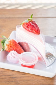 Serving fresh strawberry crepe cake, stock photo