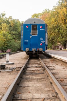 A blue train stopped in station waiting people