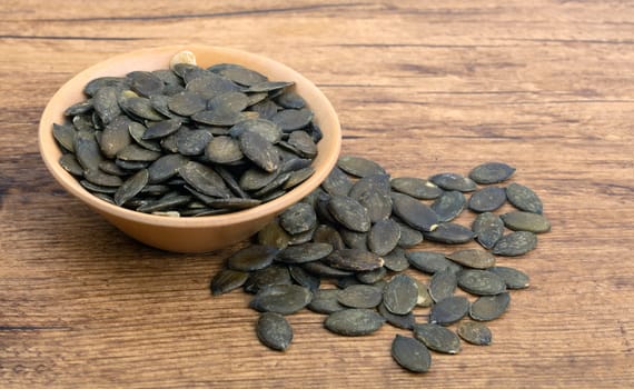 Pumpkin Seeds in a wooden Bowl on wooden Background