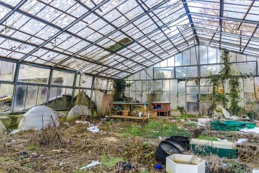 Greenhouse with broken glass, the construction is clearly visible.