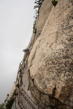 Stone steps cut on a side of a mountain rock leading to the dangerous and perilous Plank Walk trail, closed for public access due to bad weather conditions, Huashan mountain, Xian, Shaanxi Province, China