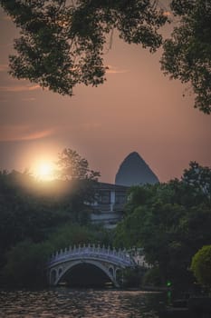 Beautiful sunset over the marble bridge on Shan Lake, Guilin town, Guangxi Province, China