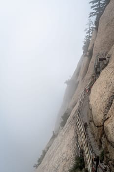 Stone steps cut on a side of a mountain rock leading to the dangerous and perilous Plank Walk trail, closed for public access due to bad weather conditions, Huashan mountain, Xian, Shaanxi Province, China