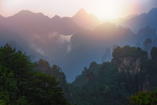 Sun shining over the stone pillars of Tianzi mountains in Zhangjiajie National park which is a famous tourist attraction, Wulingyuan, Hunan Province, China