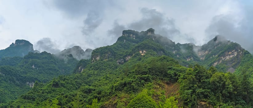 Panoramic view of the famous holy sacred Tianmen mountains covered in early morning fog and mist, Zhangjiajie, China