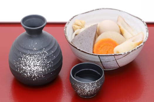 Japanese traditional sake cup and bottle with oden on tray