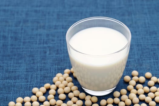 Glass of soy milk with soy bean on dining table