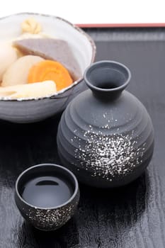 Japanese traditional sake cup and bottle with oden on tray