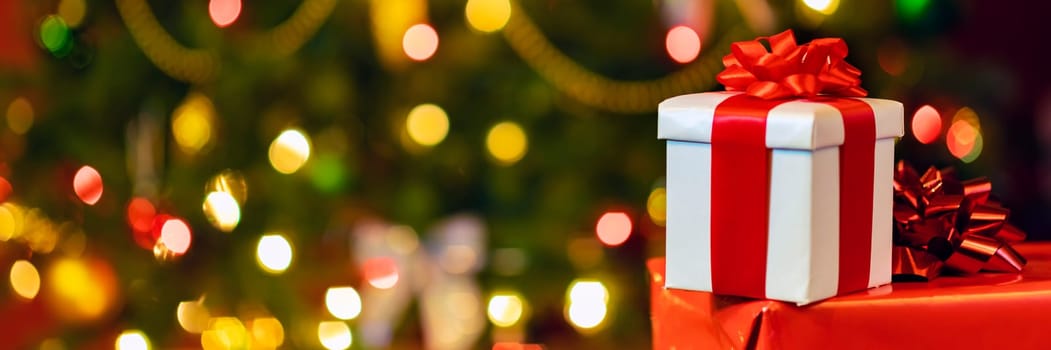 gift boxes with ribbon and bow on holiday lights background