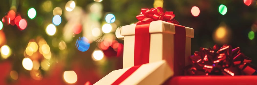 gift boxes with ribbon and bow on holiday lights background