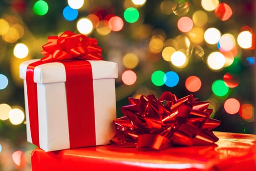gift boxes with ribbon and bow on holiday lights background