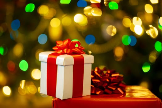 gift boxes with ribbon and bow on holiday lights background