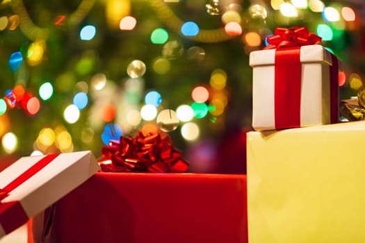 gift boxes with ribbon and bow on holiday lights background