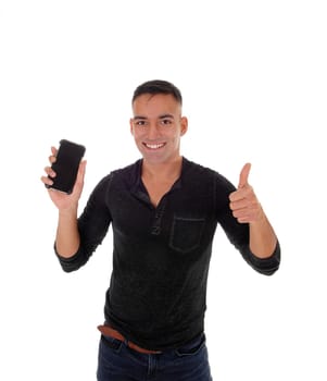 A smiling happy young man in a black shirt standing in the studio.with his phone in his hand and making victory sign, isolated for white .background.