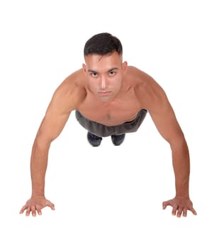A young east Indian man doing his push aps on the floor in the studio.looking into the camera, isolated for white background.