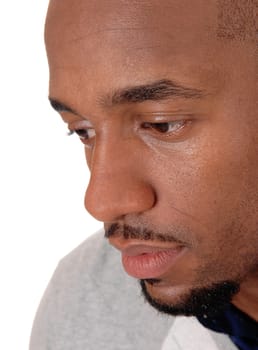 An close up image of the face of an African American man looking.down with a small beard, isolated for white background.