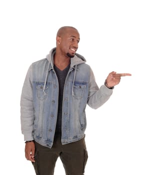 A handsome African American man standing in a jeans jacket, smiling.and pointing with his fingers at himself, isolated for white background.