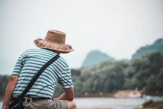 Guilin, China -  August 2019 : Unidentifiable man tourist looking at the scenery and landscape of the Li Lijiang River in Guilin, Guangxi Province