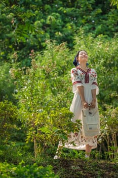 Guilin, China -  August 2019 : Chinese woman dressed in a traditional costume posing for a photograph in a public park in Guilin in summer