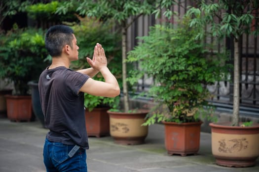 Chengdu, China - July 2019 : Chinese man praying and worshiping at the Wenshu Chinese Buddhist Temple