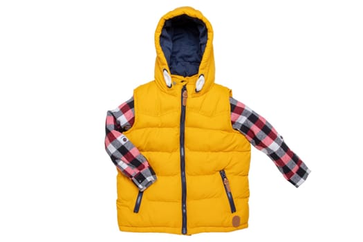 Vest isolated. Close-up of a stylish cozy warm yellow down vest with hood with a red checkered shirt isolated on a white background. Childrens autum and winter clothes.